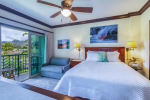 a bedroom with a bed and a chair and a window at Waipouli Beach Resort E301 in Kapaa +32 photos