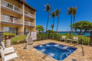 un patio con piscina y sillas frente a un edificio en Kapaa Shore C324, en Wailua