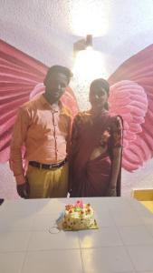 a man and a woman standing next to a table with a cake at OTP holiday homes in Kīhīm