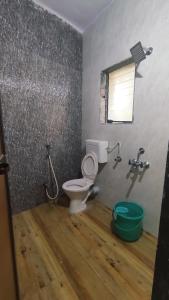 a bathroom with a toilet and a window at OTP holiday homes in Kīhīm