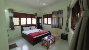 a bedroom with a bed and a table and windows at OTP holiday homes in Kīhīm