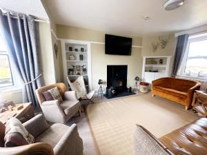 ein Wohnzimmer mit Couch und Kamin in der Unterkunft Knockenhooley Cottage in Breakish + 75 Fotos