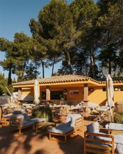 a patio with chairs and umbrellas in front of a building at Nice Camps - Lloret de Mar in Lloret de Mar