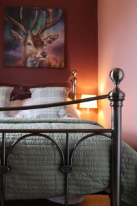 Schlafzimmer mit einem Bett mit einem Bild eines Hirsches in der Unterkunft Knockenhooley Cottage in Breakish