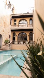 a house with a swimming pool in front of a building at Hotel Plaza de Armas in Querétaro