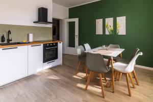 a kitchen and dining room with a table and chairs at Design ElbOase-Zentral-Parkplatz-Waschmaschine-2 separate Schlafplätze in Pirna +9 photos