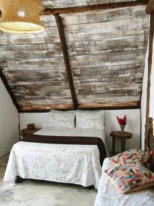 a bedroom with two beds and a wooden ceiling at Cabana Sem'ente Paraty in Paraty