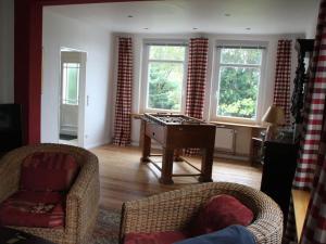 a living room with a ping pong table and chairs at Holiday home Cottage am Rhin in Glückstadt