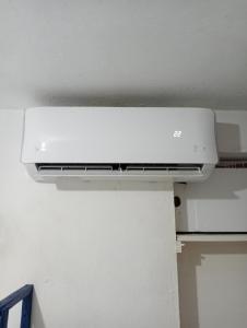 a white air conditioner on the ceiling of a room at Rhinos House in Cozumel