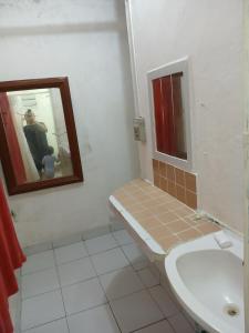 a bathroom with a toilet and a sink and a mirror at Rhinos House in Cozumel