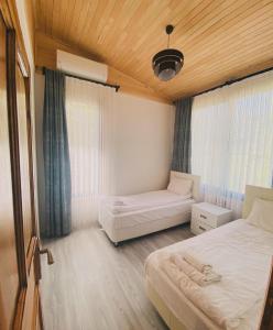a bedroom with two beds and a wooden ceiling at Black Cat Villa's in Kemer