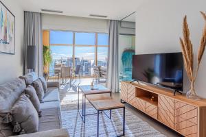 salon z kanapą i telewizorem z płaskim ekranem w obiekcie Intempo Resort & Spa by Leo Apartments w mieście Benidorm