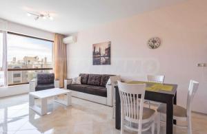 a living room with a table and a couch at La Mer Welcome in Golden Sands