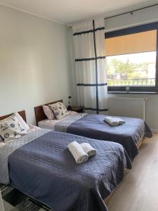 a bedroom with two beds with towels on them at Willa Klif &Spa in Jastrzębia Góra
