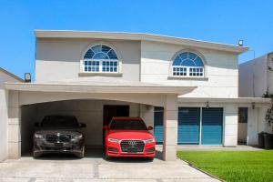 two cars parked in a garage in front of a house at FIKA Apartamentos Elite in Toluca