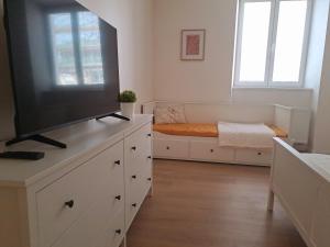 a living room with a flat screen tv on a dresser at Apartman MWM Brno in Brno