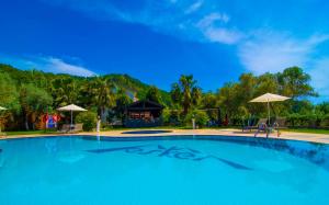 a large blue swimming pool with a gazebo at Mesken Inn Göcek Hotel in Göcek