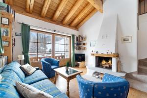 MadulainLuxury Chalet St Moritz with View - 4 Bedrooms的带蓝色沙发和壁炉的客厅