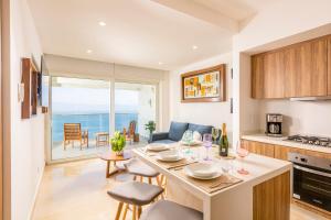 a kitchen and living room with a table and chairs at Harbor NT2505 by Moikkarentals in Puerto Vallarta