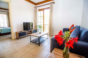 a living room with a blue couch and a tv at Mesken Inn Göcek Hotel in Göcek