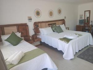 two beds sitting in a room with at Foundation Stones Lodge Summerstrand in Gqeberha