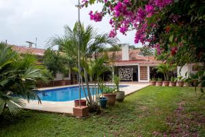 ein Haus mit einem Pool und Palmen in der Unterkunft Quinta San Miguel Ricaurte in Ricaurte