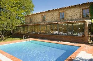 a swimming pool in front of a house at Cortijo Rural Finca HUERTA SANTA MARÍA in Galaroza