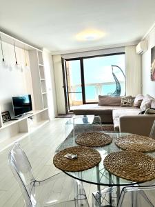a living room with a glass table and a couch at La Mer Welcome in Golden Sands