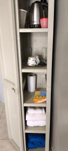 a white pantry with towels and a pot at Monoambiente Coqueto in Venado Tuerto