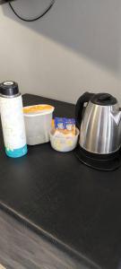 a tea kettle and containers on a black counter at Monoambiente Coqueto in Venado Tuerto