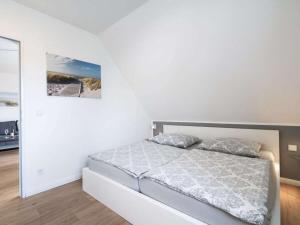 a white bedroom with a bed and a mirror at holiday apartment with 2 bedrooms in Timmendorfer Strand +18 photos