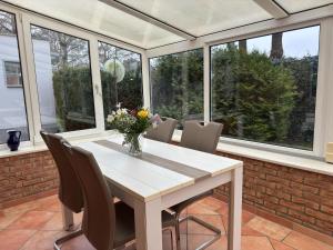 a dining room with a table and chairs and windows at Ferienhaus mit Garten in Graal-Müritz in Graal-Müritz