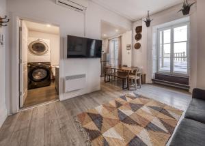 a living room with a tv and a table at North House - Des Remparts- 2-bed with great views, terrace in Quebec City