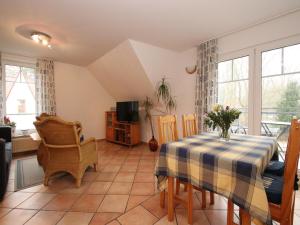 Una sala de estar con una mesa y un televisor. en Graal-Müritz Garden Balcony Stay, en Graal-Müritz