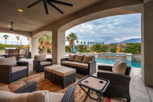 an outdoor patio with a pool and chairs and a table at Coachella Dream - Luxury Mid-Term Rental in Indio