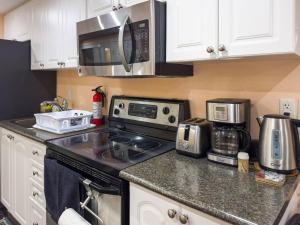 a kitchen with a stove and a microwave at Private - Spacious with Jacuzzi and Great Location in Mississauga