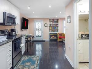 a kitchen with white cabinets and a living room at Private - Spacious with Jacuzzi and Great Location in Mississauga