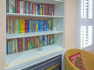a book shelf filled with books next to a window at Private - Spacious with Jacuzzi and Great Location in Mississauga