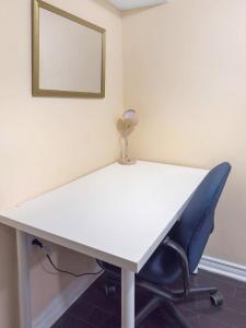 a white desk with a chair and a mirror at Private - Spacious with Jacuzzi and Great Location in Mississauga