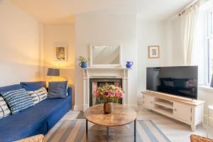a living room with a blue couch and a tv at Clitheroe Wilson Retreat. Central Lancashire in Clitheroe