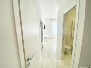 a white bathroom with a toilet and a mirror at IL VIAGGIATORE RELAIS SUL MARE in Gaeta