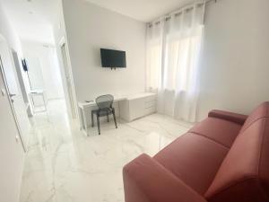 a living room with a couch and a desk with a television at IL VIAGGIATORE RELAIS SUL MARE in Gaeta