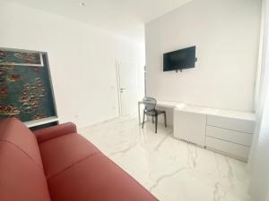 a living room with a couch and a desk and a television at IL VIAGGIATORE RELAIS SUL MARE in Gaeta