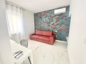 a red couch in a room with a wall at IL VIAGGIATORE RELAIS SUL MARE in Gaeta