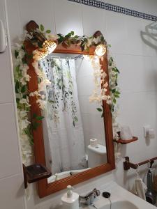 a bathroom mirror with a sink and flowers on it at Apartamento Rural Casa Mar in El Bosque +55 photos