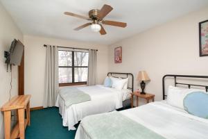 a bedroom with two beds and a ceiling fan at Cozy Smoky Mountain Escape w/ Private Deck & Community Pool in Pigeon Forge