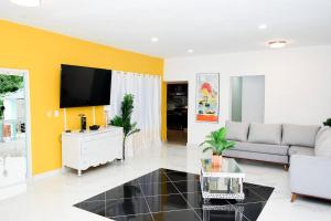 a living room with a couch and a tv at Villa Oceanic Dream in San Felipe de Puerto Plata