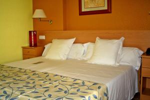 a bed with white pillows in a hotel room at Montreal in Benicàssim