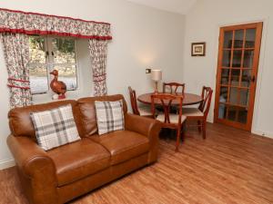 a living room with a couch and a table at Tile Rouge in Wooler