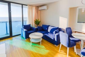 a living room with a blue couch and a table at Orbi Batumi in Batumi